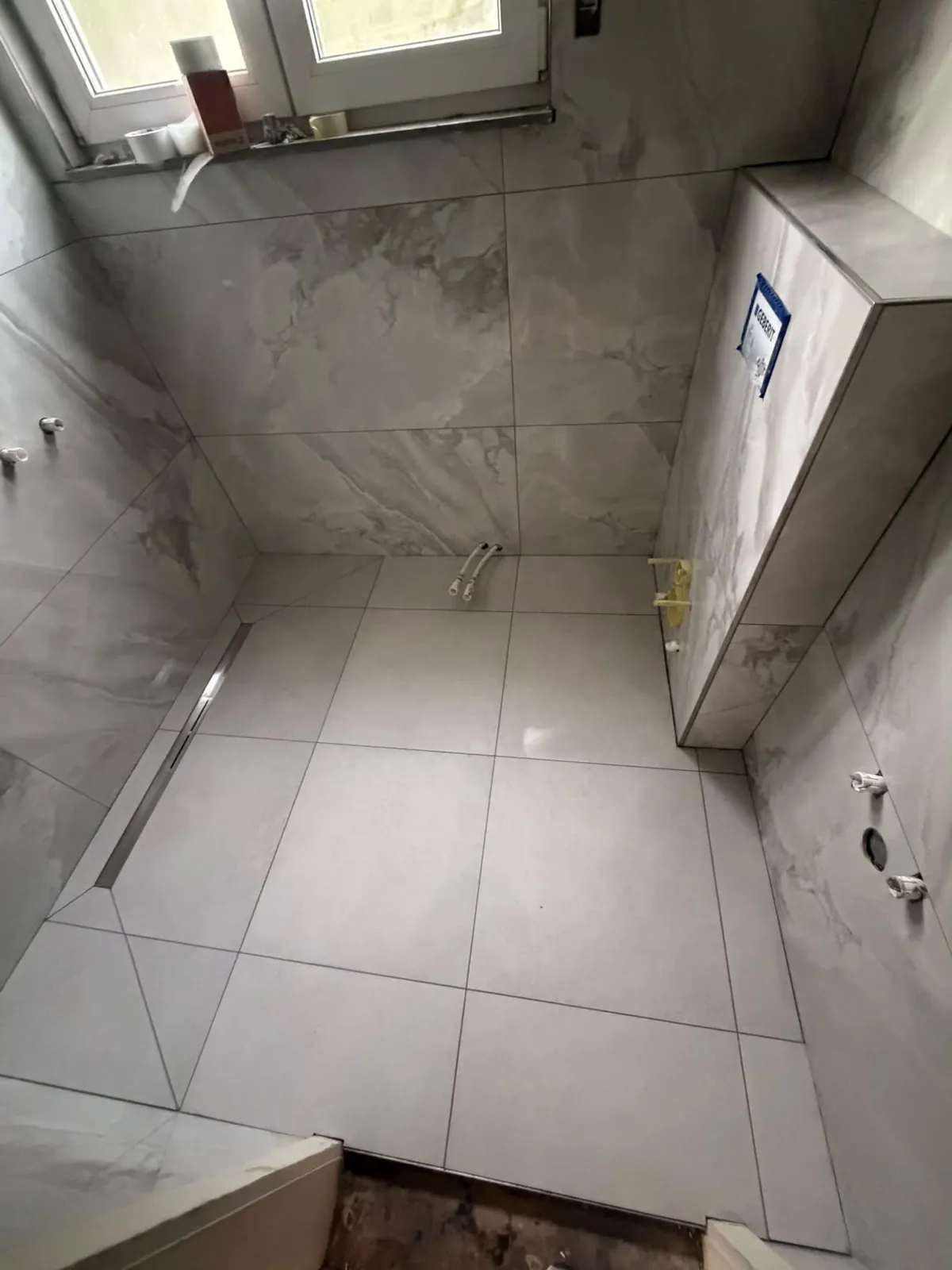Saniertes Bad in Marmoroptik mit bodengleicher Dusche